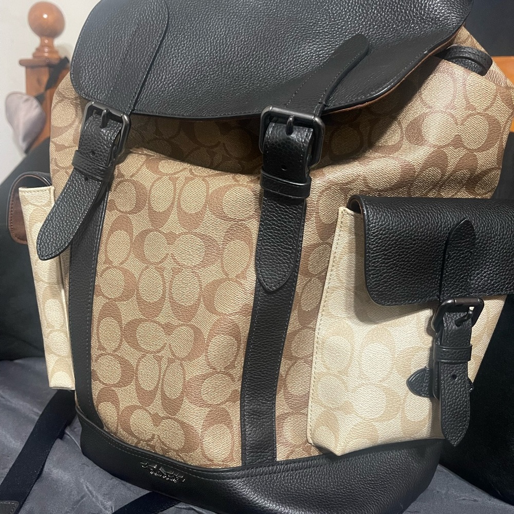 Mens coach backpack. Tan and black color way with button straps.